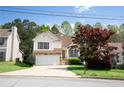 Inviting two-story home with stone accents, a two-car garage, and mature trees at 4032 Robin Cir, College Park, GA 30349