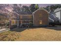 Traditional brick home with a covered front porch and well-maintained lawn at dusk at 5000 Bainbridge Sw Ct, Lilburn, GA 30047