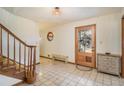 A tiled foyer with a wooden staircase, decorative accents, and natural light at 5000 Bainbridge Sw Ct, Lilburn, GA 30047