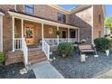 Inviting front porch with white railing, a wooden door, and charming landscaping, creating a warm entrance at 5000 Bainbridge Sw Ct, Lilburn, GA 30047