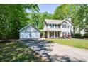 View of a two-story house and two-car garage, set back from the street with a long driveway at 605 Sutton Sw Way, Marietta, GA 30064