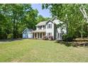 Two-story house featuring a well-maintained lawn and a gray exterior, complemented by dark shutters and a two-car garage at 605 Sutton Sw Way, Marietta, GA 30064