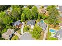 Aerial view of a home with a pool surrounded by lush greenery in a residential neighborhood at 3105 Birchton St, Johns Creek, GA 30022