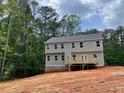 Two-story home's back exterior with a new wood deck overlooking a partially wooded lot at 3294 Mill Forest Dr, Conyers, GA 30094