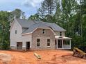 Two-story brick home with gray siding, an attached garage, and a covered front porch at 3294 Mill Forest Dr, Conyers, GA 30094