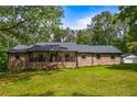 Inviting brick home with a spacious front porch, complemented by a well-manicured lawn and mature shade trees at 3400 Bonds Lake Nw Rd, Conyers, GA 30012