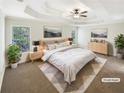 Serene main bedroom showcasing a tray ceiling, neutral color palette, and ample natural light at 6105 Ivey Hill Dr, Cumming, GA 30040
