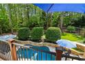 Backyard view of a pool with a lounge area and green surroundings at 3115 Corsair Curv, Cumming, GA 30040