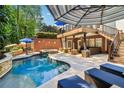 Inviting in-ground pool with lounge seating and covered patio area at 3115 Corsair Curv, Cumming, GA 30040