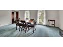 Spacious dining room with blue carpet, dining table, and natural light from large windows at 5618 Fern Creek Sw Dr, Lilburn, GA 30047