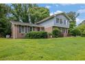 Two-story brick home with blue siding, black shutters, and a green lawn on a sunny day at 5618 Fern Creek Sw Dr, Lilburn, GA 30047
