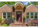 Inviting front entrance with a dark wood door framed by brick and decorative plantings at 1256 Spring Valley Ne Ln, Atlanta, GA 30306