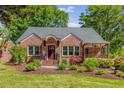 Charming red brick house with manicured lawn, mature landscaping, and inviting front entrance at 1256 Spring Valley Ne Ln, Atlanta, GA 30306