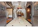 Grand foyer featuring marble flooring, wrought iron staircase, and ornate chandelier, radiating elegance at 2120 Blackheath Trce, Alpharetta, GA 30005