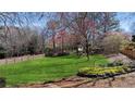 Expansive backyard featuring a lush lawn, wooden fence, and mature trees at 720 Lakeglen Dr, Suwanee, GA 30024