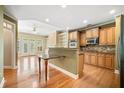 Open-concept kitchen with granite countertops, stainless steel appliances, and breakfast bar flowing into the living area at 8215 Majors Mill Dr, Cumming, GA 30041