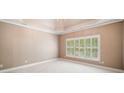 Spacious main bedroom with a trey ceiling, large window, and plush carpet at 8215 Majors Mill Dr, Cumming, GA 30041