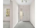Bright entryway featuring neutral carpet, a chandelier, and a front door with a sidelight window at 1715 E Clifton Ne Rd, Atlanta, GA 30307