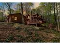Inviting log home featuring a cozy front porch with evening lights among mature trees at 6515 Namon Wallace Dr, Cumming, GA 30028