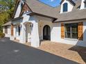 Elegant home entrance with brick accents, arched doorway and wood shutters at 3920 Maybreeze Rd, Marietta, GA 30066