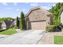 View of the stone and brick home with beautiful landscaping and a spacious driveway leading to a two-car garage at 3739 Union Park Dr, Duluth, GA 30097