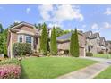 Landscaped front yard with brick and stone exterior, manicured lawn, and vibrant flower beds enhancing curb appeal at 3739 Union Park Dr, Duluth, GA 30097
