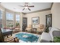 Elegant living room with bay window, ornate decor, ceiling fan, and hardwood floors offers a bright and airy feel at 3739 Union Park Dr, Duluth, GA 30097