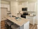 Modern kitchen with stainless steel appliances, granite counters, and a center island at 2674 Ne Almand Ne Ln, Conyers, GA 30013