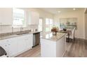 Bright kitchen featuring an island with granite countertop, stainless steel appliances, and a view to the dining area at 2680 Ne Almand Ne Ln, Conyers, GA 30013