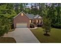 Charming brick home featuring a columned front porch and a well-manicured lawn at 5071 Woodmont Dr, Villa Rica, GA 30180