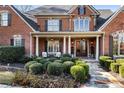 Stately brick home featuring a covered front porch with elegant columns at 13230 Addison Rd, Roswell, GA 30075