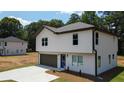 Two-story home featuring a paved driveway leading to an attached garage, complemented by a manicured lawn at 1341 E Atlanta E Rd, Stockbridge, GA 30281