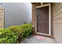 Front door featuring brick surround and landscaped bushes at 5885 San Gabriel Ln, Atlanta, GA 30349
