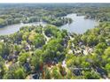 Aerial view of property at 7389 Tidewater Trace, nestled in a wooded area near a lake at 7389 Tidewater Trce, Stone Mountain, GA 30087