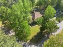 Aerial view of a yellow home with a large yard surrounded by lush green trees at 7389 Tidewater Trce, Stone Mountain, GA 30087