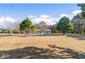 Exterior view of blue single story home with a brown roof and large grassy front yard and mature trees at 900 Stone Lea Trce, Oxford, GA 30054