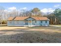 Charming single story home with blue siding, a large front yard, and a welcoming front porch at 900 Stone Lea Trce, Oxford, GA 30054