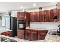 Well-equipped kitchen featuring dark wood cabinets, granite countertops, and stainless steel appliances at 900 Stone Lea Trce, Oxford, GA 30054