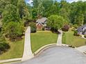 Charming brick home with lush landscaping, long driveways, and mature trees at 204 Overland Trl, Mcdonough, GA 30252