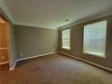 Comfortable living room with neutral carpet, trim, and two large windows at 2752 Live Oak Trl, Atlanta, GA 30349
