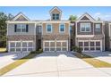 Three modern townhomes, each with two-car garages and distinct color schemes, line a spacious driveway at 38 Trailview Ln, Hiram, GA 30141