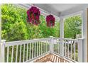View from the balcony showing hanging flower baskets and lush greenery in the background at 5566 River Heights Se Xing, Marietta, GA 30067