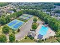 Aerial shot showcasing tennis courts and sparkling blue swimming pool at 841 Sapphire Ln, Sugar Hill, GA 30518