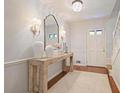 Elegant entryway with a wooden console table, decorative mirror, and stylish lighting fixtures at 2567 Hyde Manor Nw Dr, Atlanta, GA 30327