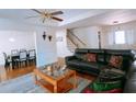 Open concept living room with hardwood floors, black sectional couch, and staircase at 385 Bethesda Park Trl, Lawrenceville, GA 30044