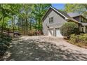Wide driveway leading to a two-car garage, surrounded by lush landscaping and trees at 5876 Bridgemont Nw Pl, Acworth, GA 30101
