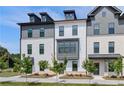 Striking townhome exteriors with a mix of brick, siding, dark trim, and dormer windows under a bright blue sky at 529 Rubato Knl, Mcdonough, GA 30253