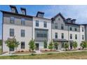 Contemporary townhome exteriors featuring white brick, dark gray trim, and dormer windows for added architectural detail at 529 Rubato Knl, Mcdonough, GA 30253