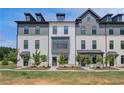 Beautiful townhomes with a combination of white brick and siding under a dark roofline for a sleek, modern aesthetic at 529 Rubato Knl, Mcdonough, GA 30253