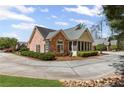 Charming stone and siding home with manicured landscaping, circular drive, and screened porch at 1304 Brookhavenrun Cir, Duluth, GA 30097